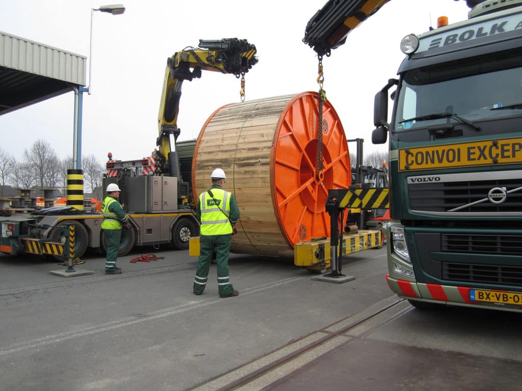 Een zware lading wordt gelost door middel van autolaadkranen